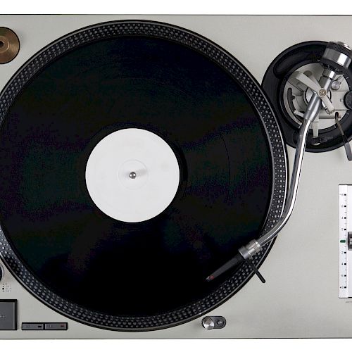 The image shows a vinyl record on a turntable, including a tonearm and stylus, used for playing music from records.