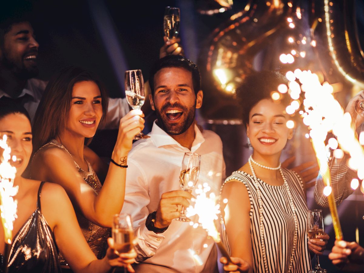 A group of people celebrating with sparklers and champagne, enjoying a festive event or party.